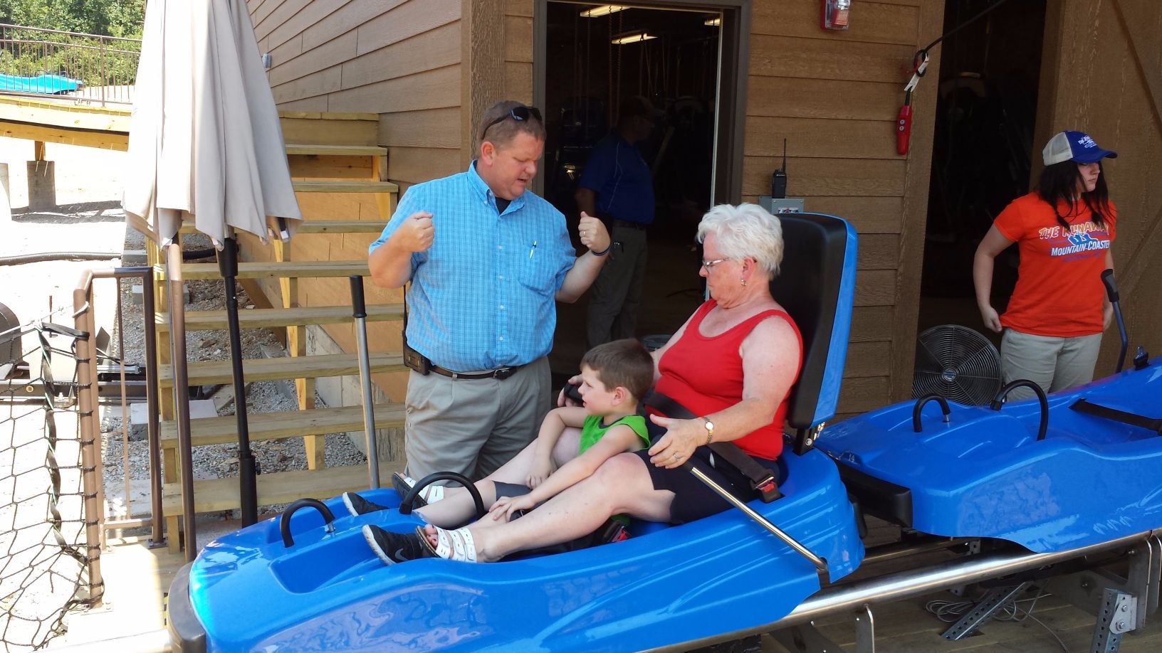 Man talking to woman and child while riding in coaster