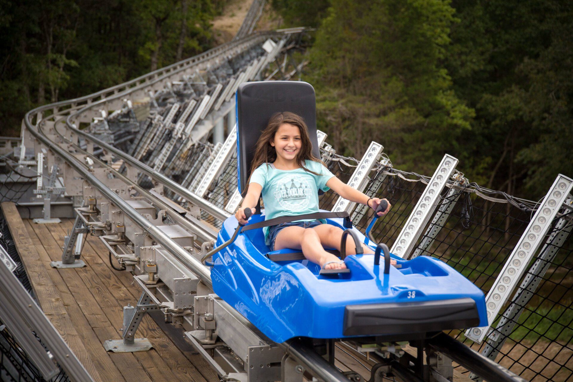 A girl enjoying riding in blue coaster