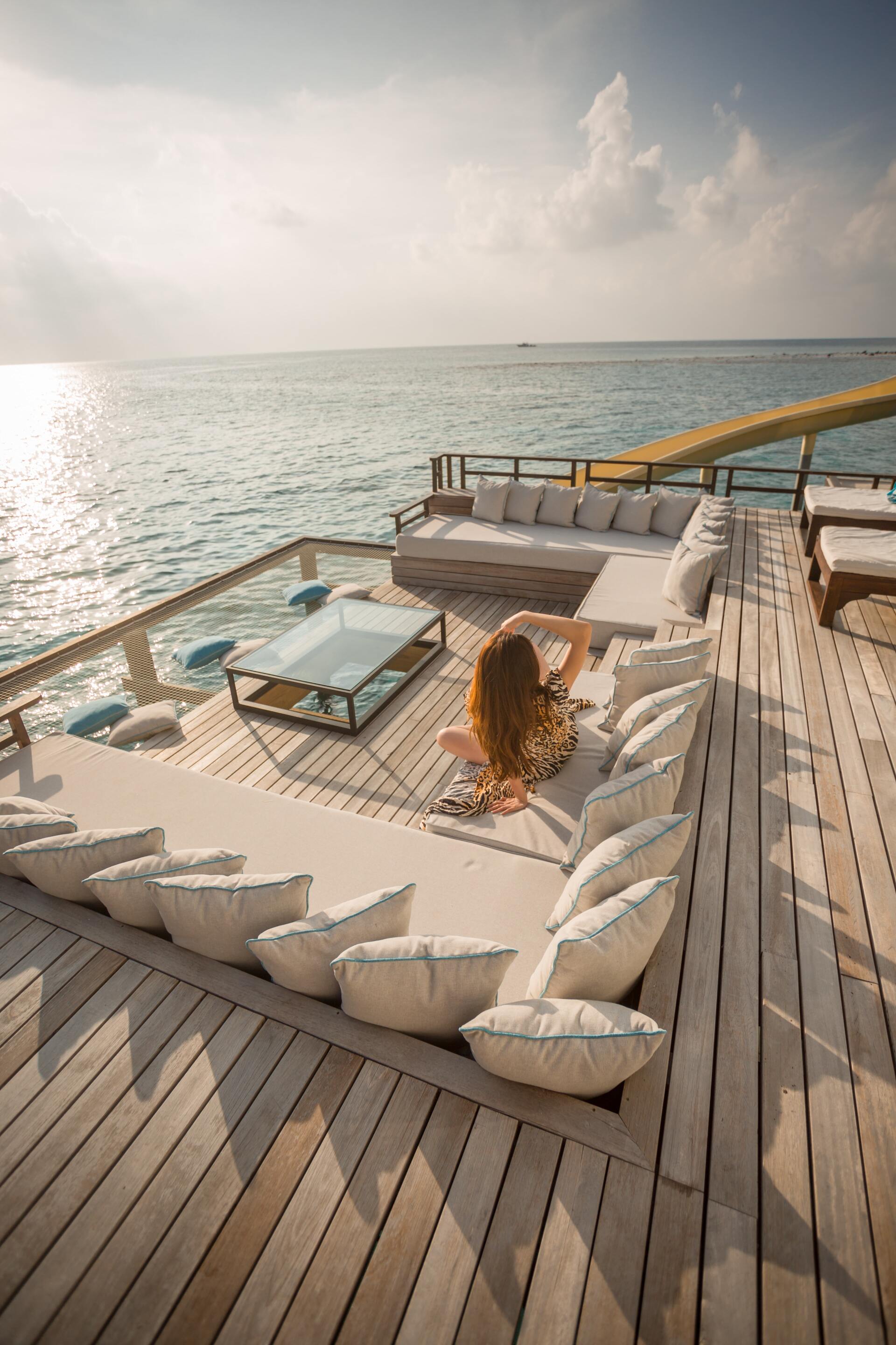 Woman relaxing on a yacht’s spacious outdoor deck at sunset