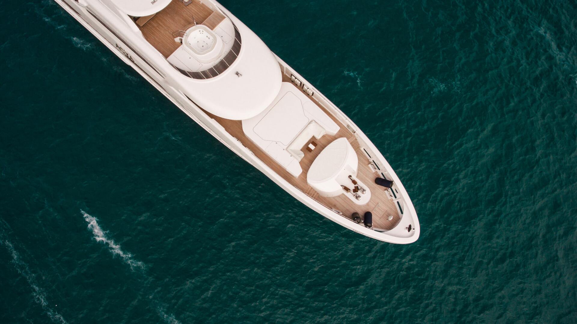 Overhead shot of a luxury yacht floating on deep teal water