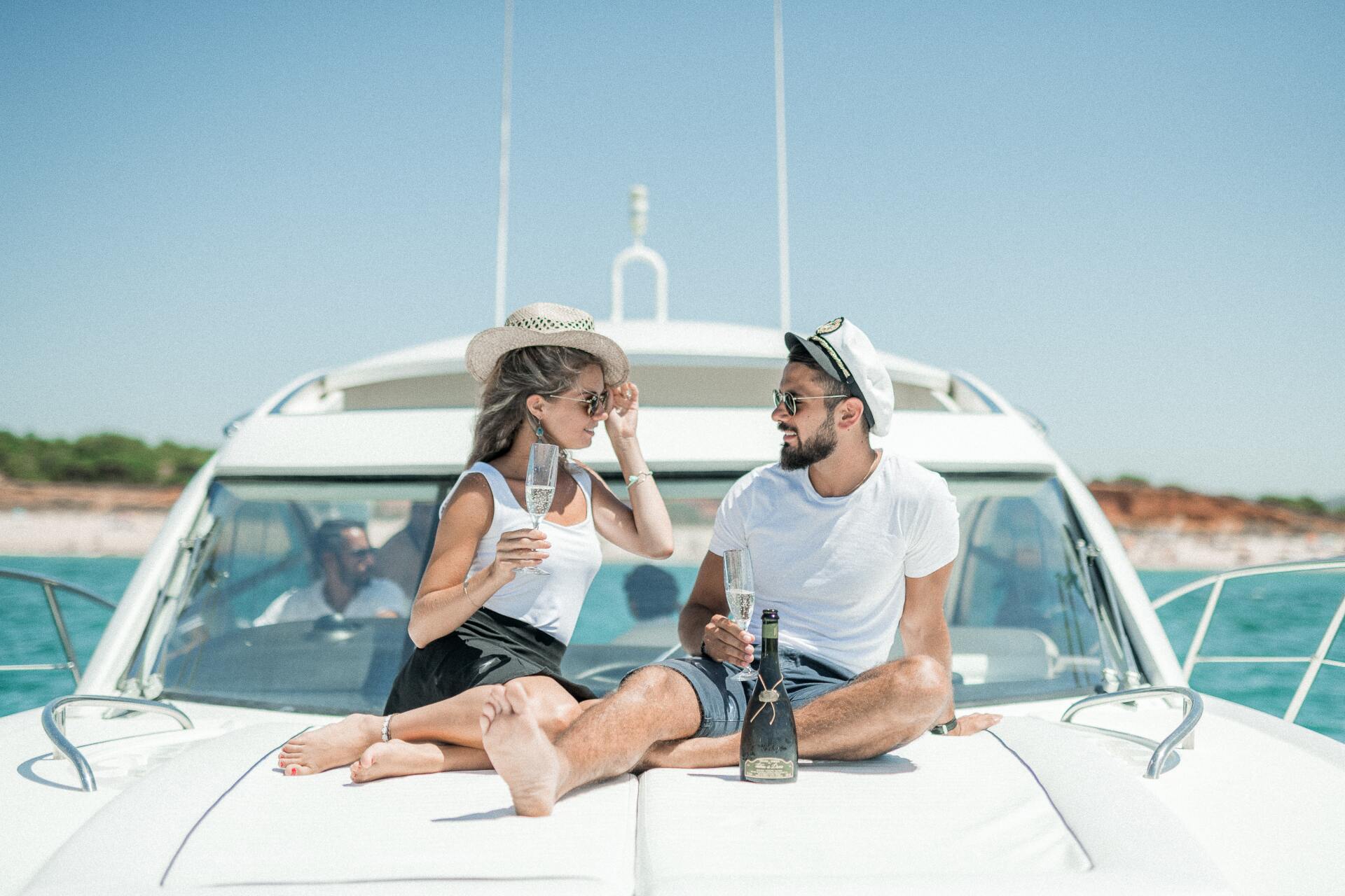 Couple enjoying drinks and conversation on the bow of a white yacht