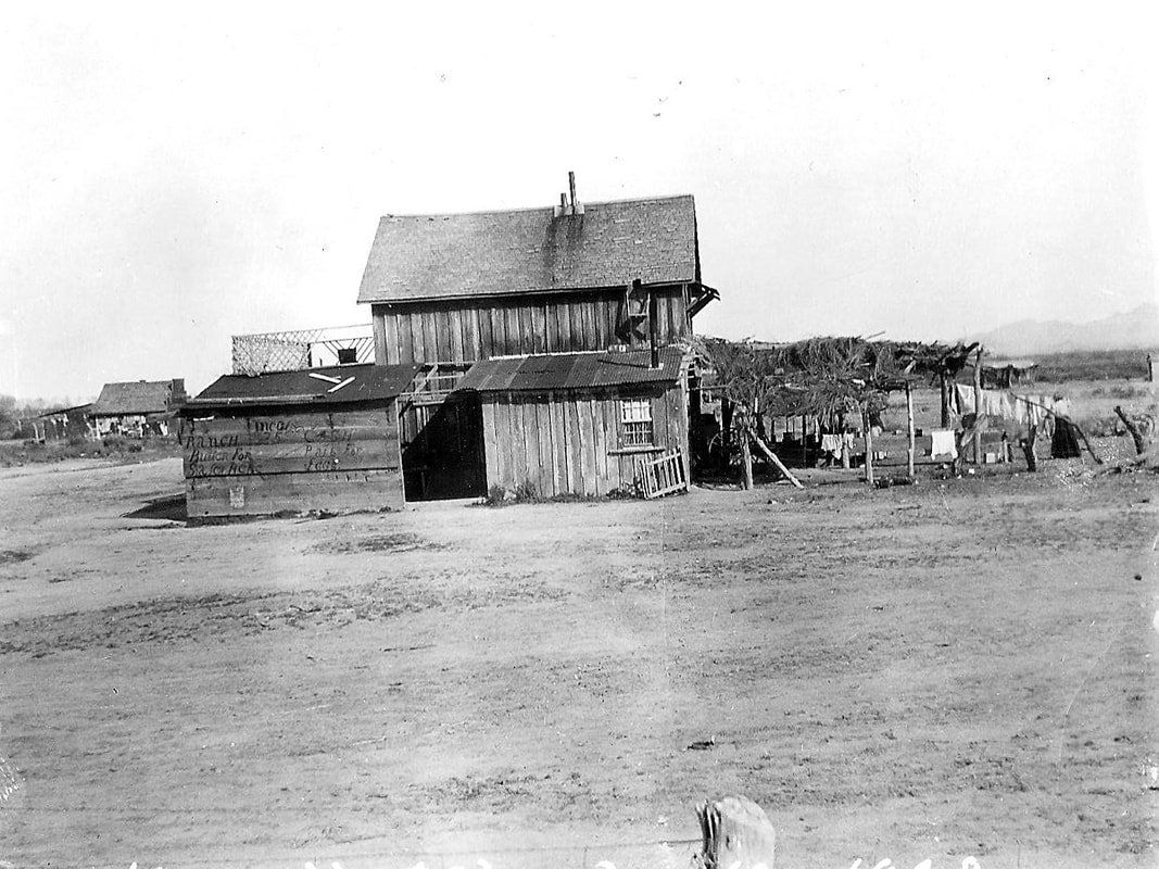 A black and white photo of a house in the middle of a field.