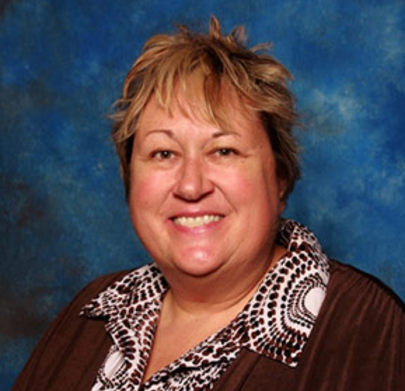 A close up of a woman wearing a blue shirt and smiling.