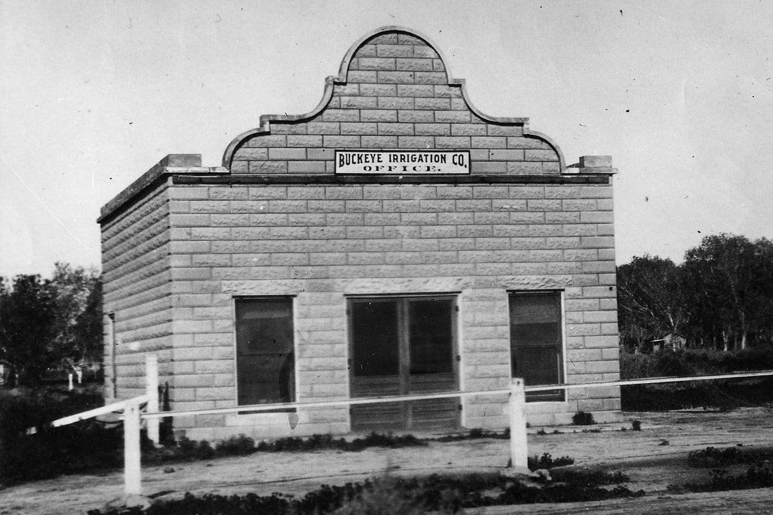 A black and white photo of a brick building with a sign on the top that says ' james walker '