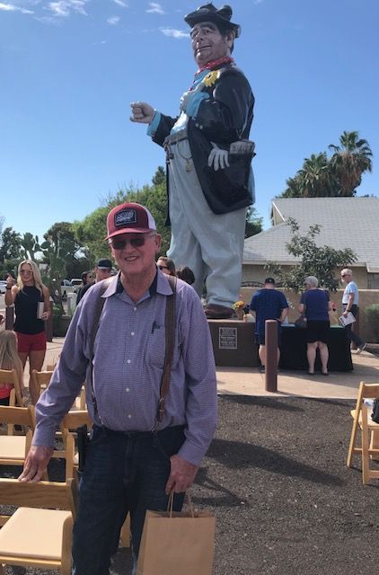 A man standing in front of a statue of a man