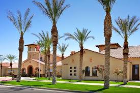 A row of palm trees in front of a building.