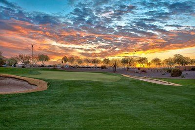 A golf course with a sunset in the background.