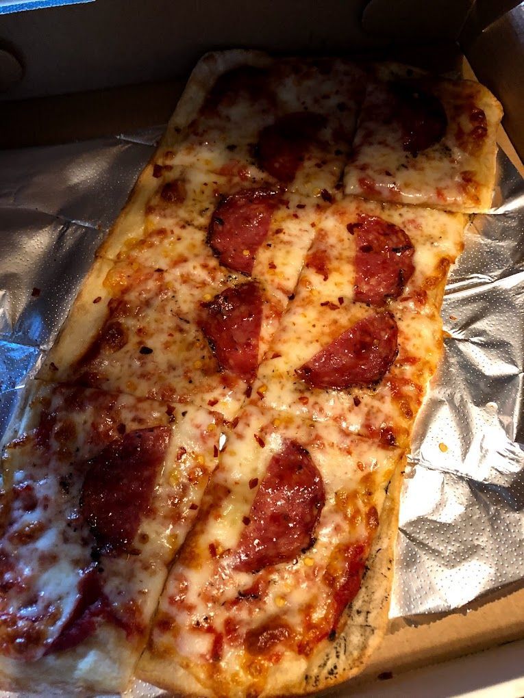A pepperoni pizza is sitting on top of a piece of tin foil.