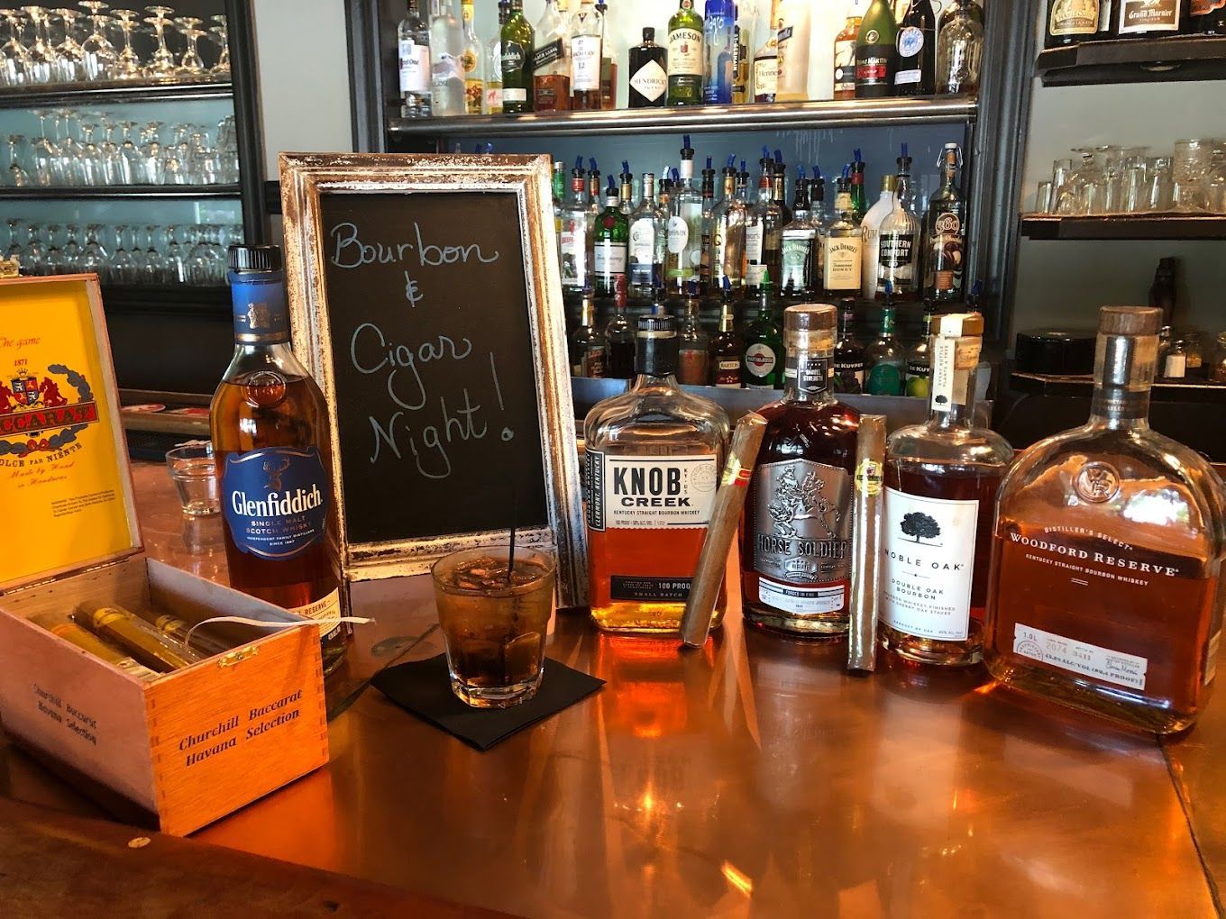 A bar with bottles of whiskey and cigars on it