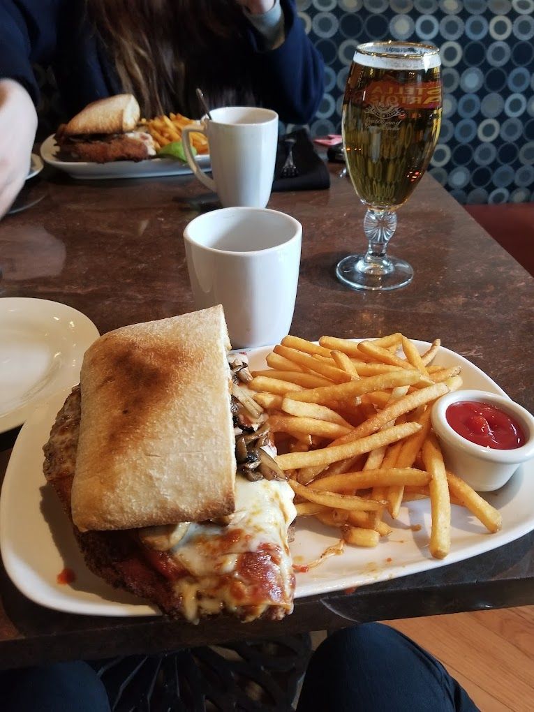 A sandwich and french fries are on a plate on a table