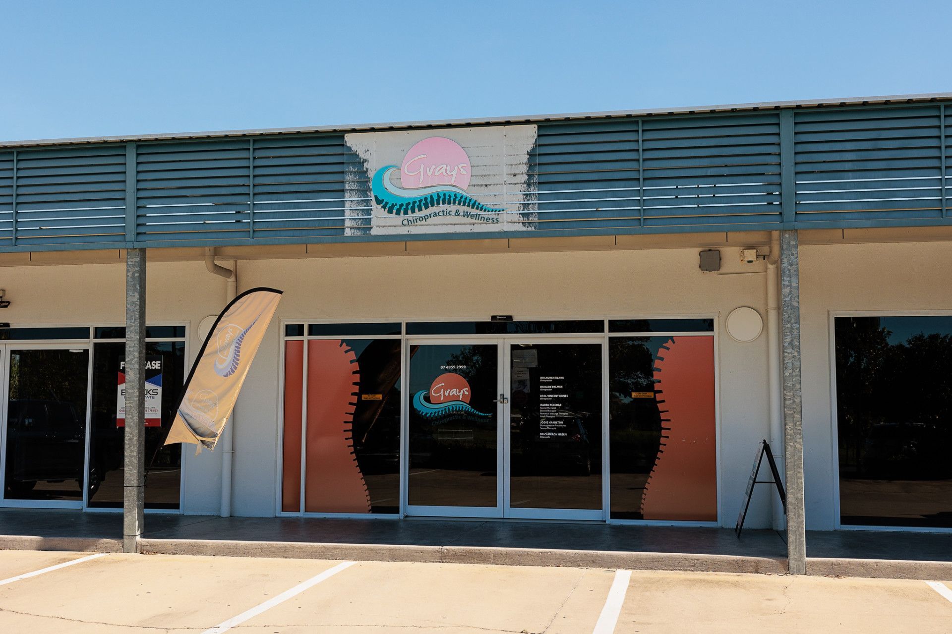 A storefront with a blue awning. The sign says