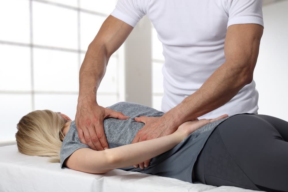 Man Giving Back Massage to Woman in Treatment Room — Grays Chiropractic & Wellness In Paget, QLD