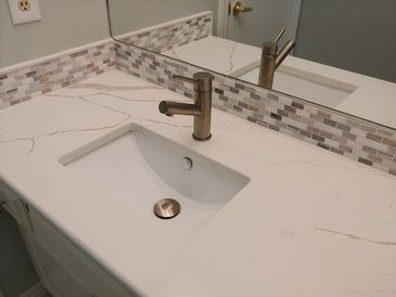 A bathroom sink with a faucet and a mirror.