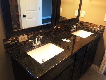 A bathroom with two sinks and two mirrors.