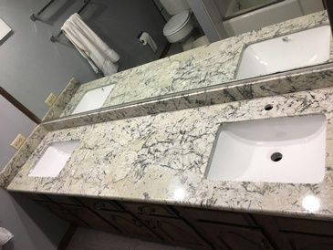 A bathroom with two sinks and a large mirror.