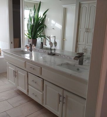 A bathroom with two sinks and a large mirror