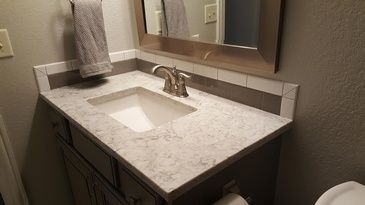 A bathroom with a sink , mirror and toilet.