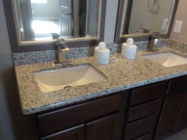 A bathroom with two sinks and two mirrors.