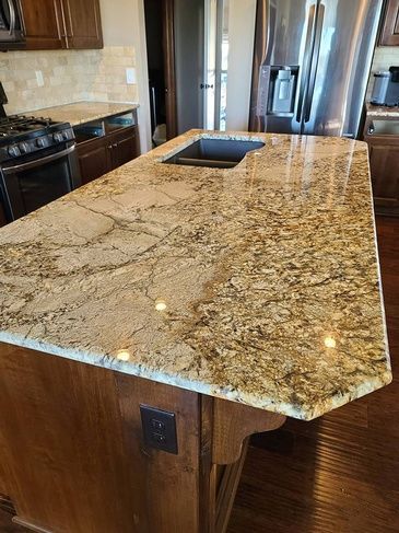 A kitchen with a large granite counter top and a sink.