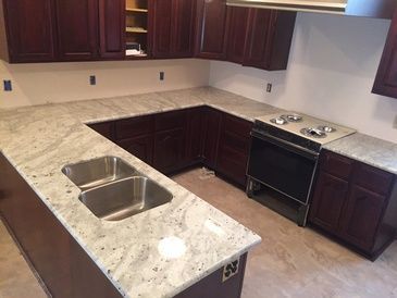 A kitchen with stainless steel appliances and granite counter tops.