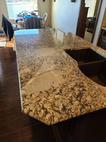 A kitchen with a granite counter top and a sink.
