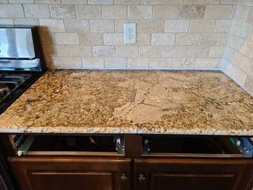 A kitchen with a granite counter top and a stove top oven.