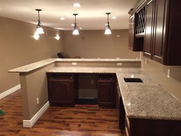 A kitchen with granite counter tops and wooden cabinets.