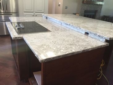 A kitchen with granite counter tops and a stove top oven.