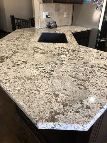 A kitchen with a granite counter top and a sink.