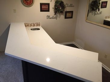 A white counter top in a room with a mirror.