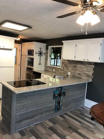 A kitchen with a large island and a ceiling fan.