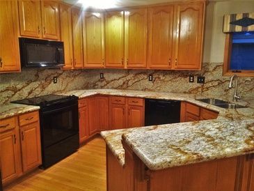 A kitchen with wooden cabinets and granite counter tops.