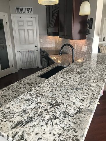 A kitchen with granite counter tops and a black sink.