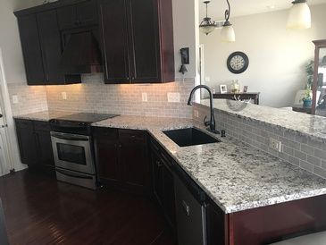 A kitchen with granite counter tops and stainless steel appliances.
