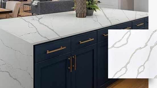 A kitchen island with a marble counter top and blue cabinets.