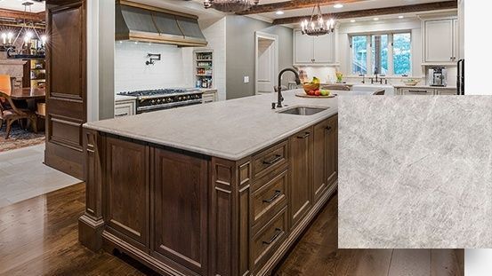 A kitchen with a large island in the middle and a granite counter top.