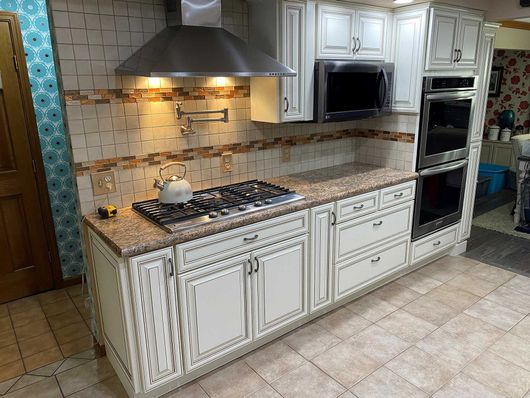 Kitchen counter and cabinets after work by Premier Kitchen Cabinet Refacing
