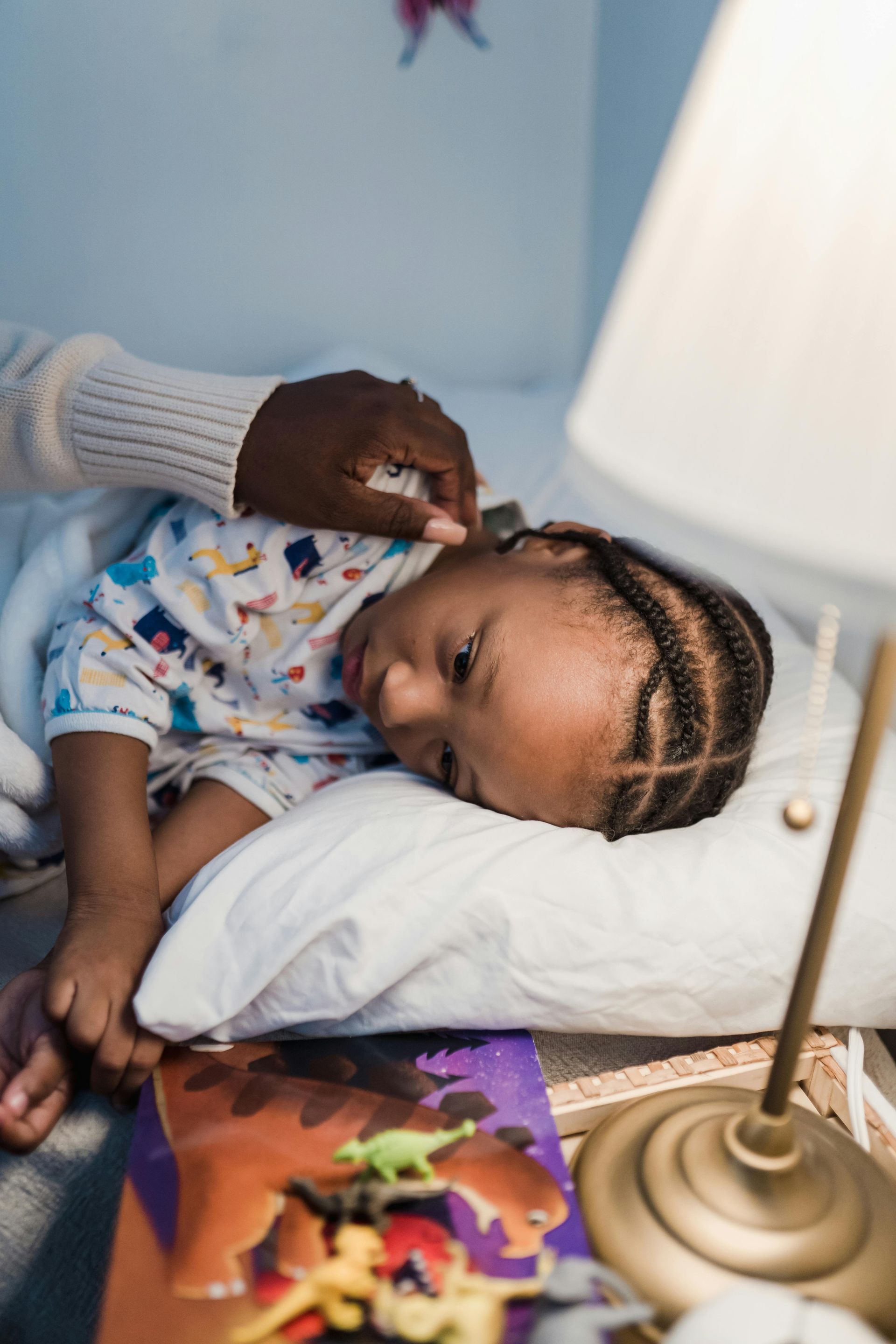 Young child resting peacefully during overnight childcare with stuffed animal and bedtime story book