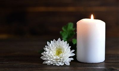 A White Candle With A Flower — Brunswick, MD — John T. Williams Funeral Home