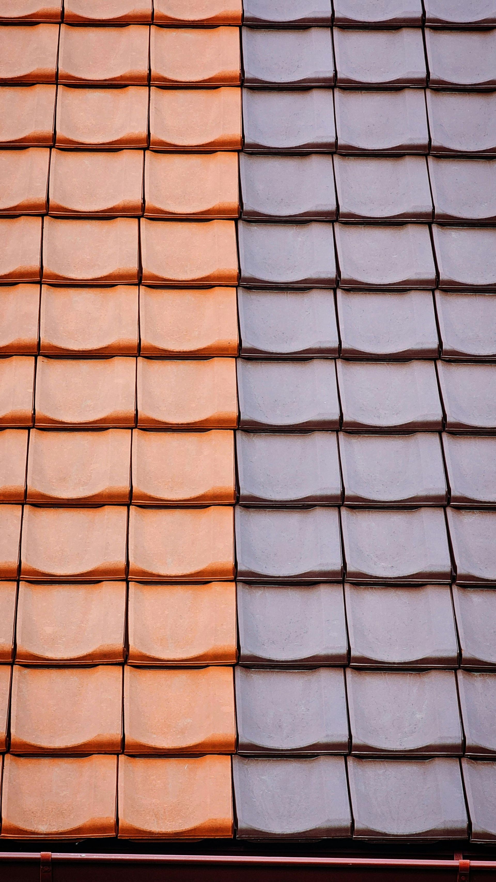 Side-by-side roof tiles in orange and gray.