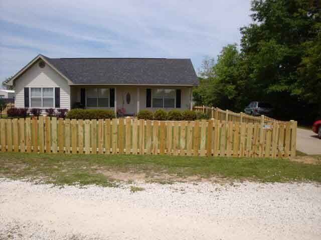 A house with a wooden fence in front of it