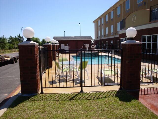 A fence surrounds a swimming pool in front of a building