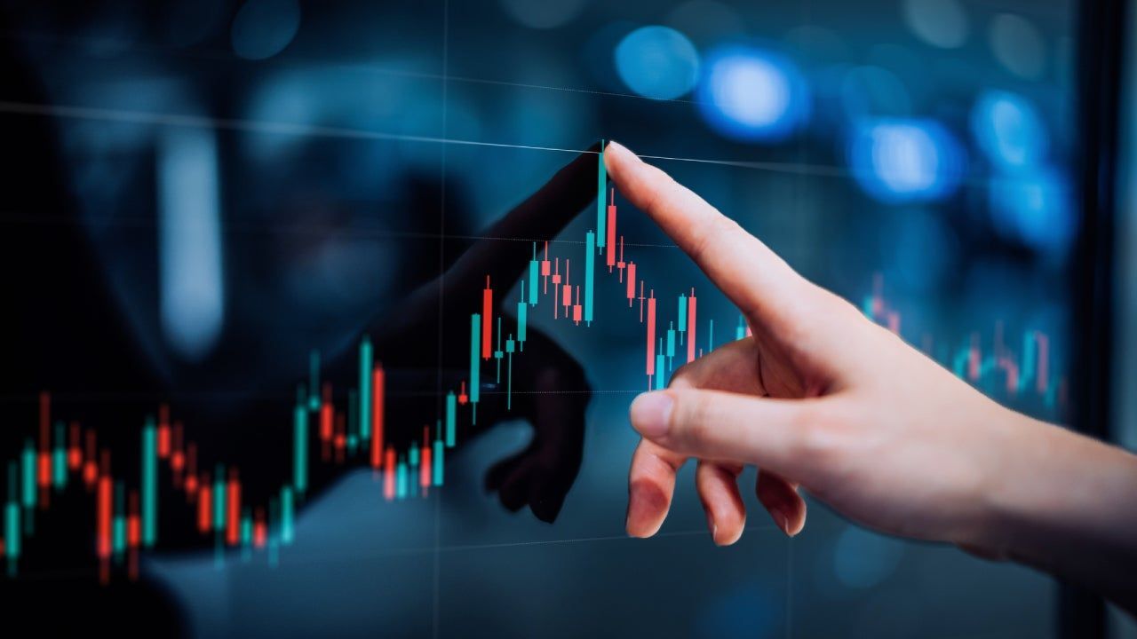 A person is pointing at a graph on a screen.