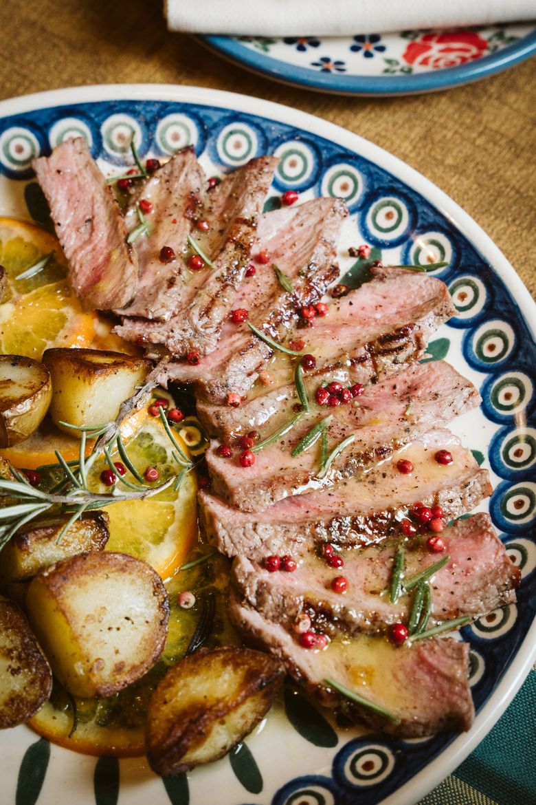 Bistecca tagliata a fette e cotta su un piatto decorativo, guarnita con rosmarino.