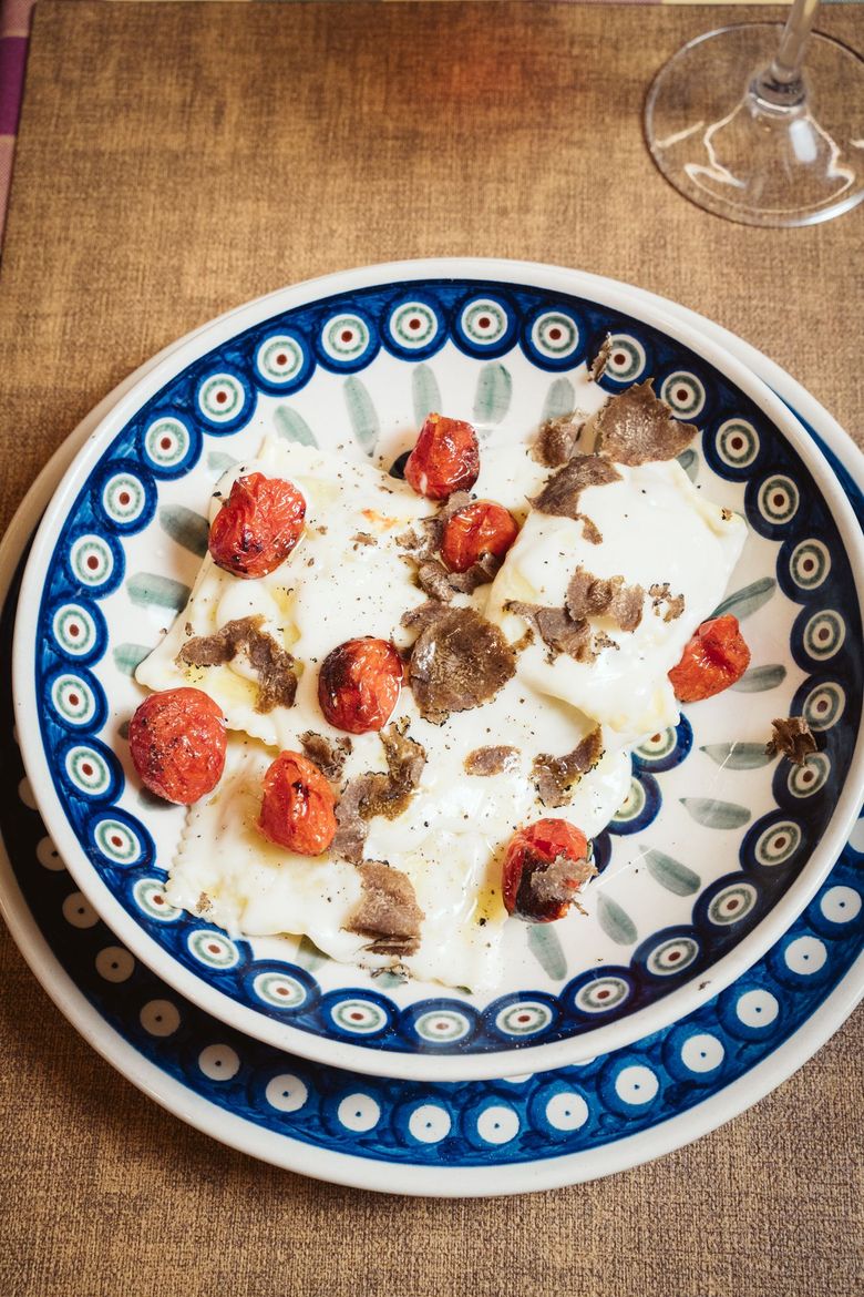 Pasta al ragù in una ciotola decorativa, su una superficie metallica vicino ai fornelli.