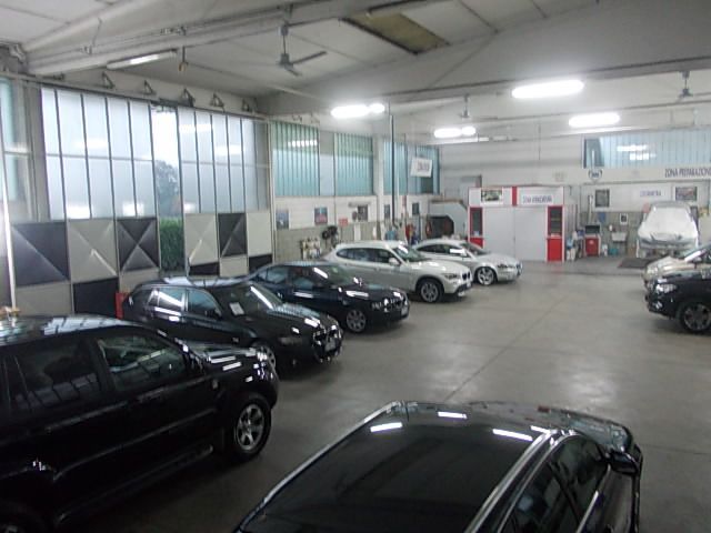 Auto all'interno di un'officina, con particolare attenzione ai veicoli e all'ambiente industriale.