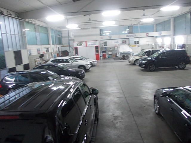 Auto parcheggiate all'interno di un  autocarrozzeria