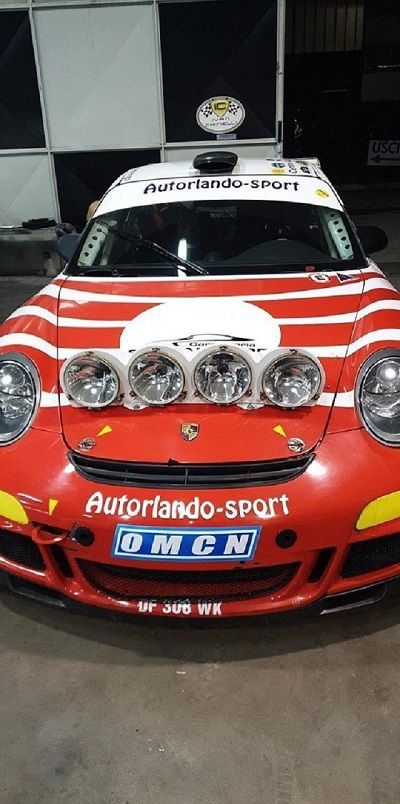 Porsche rossa con luci da rally e decalcomanie