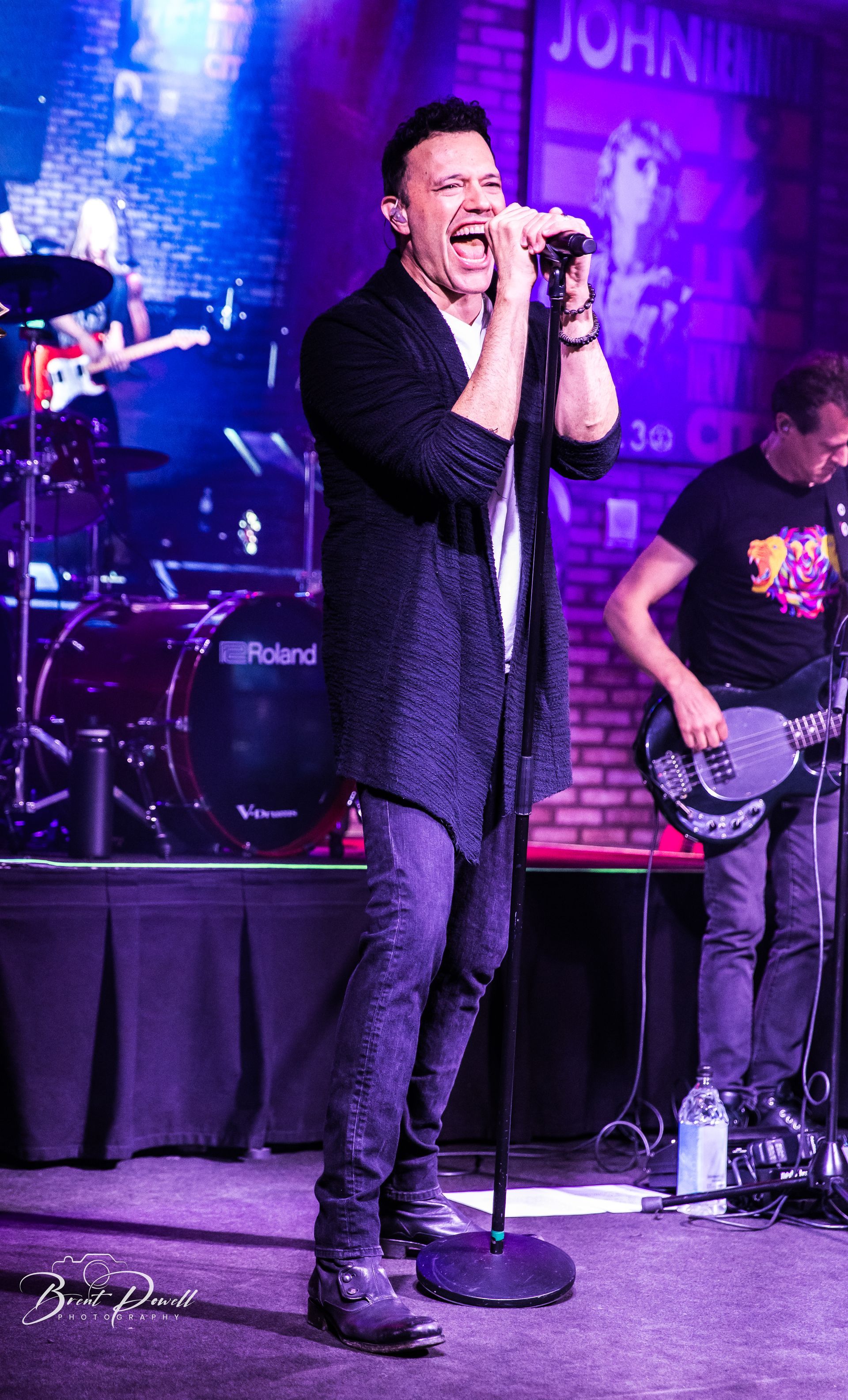 A man is singing into a microphone on a stage.