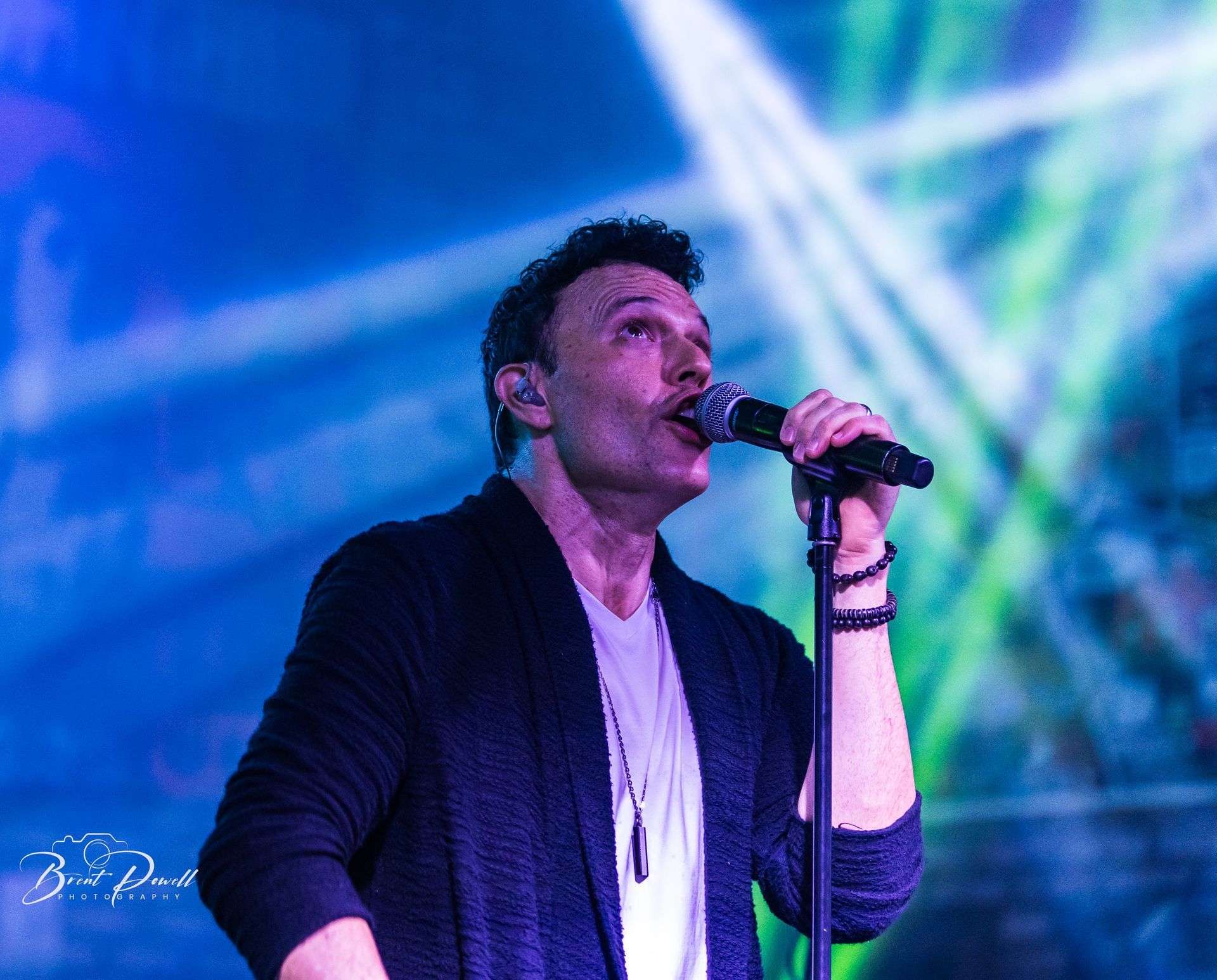 A man is singing into a microphone on a stage.